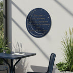 Deep navy blue finish of the personalized metal moon sign displayed on a sunlit white patio wall above a dark blue outdoor dining table set.