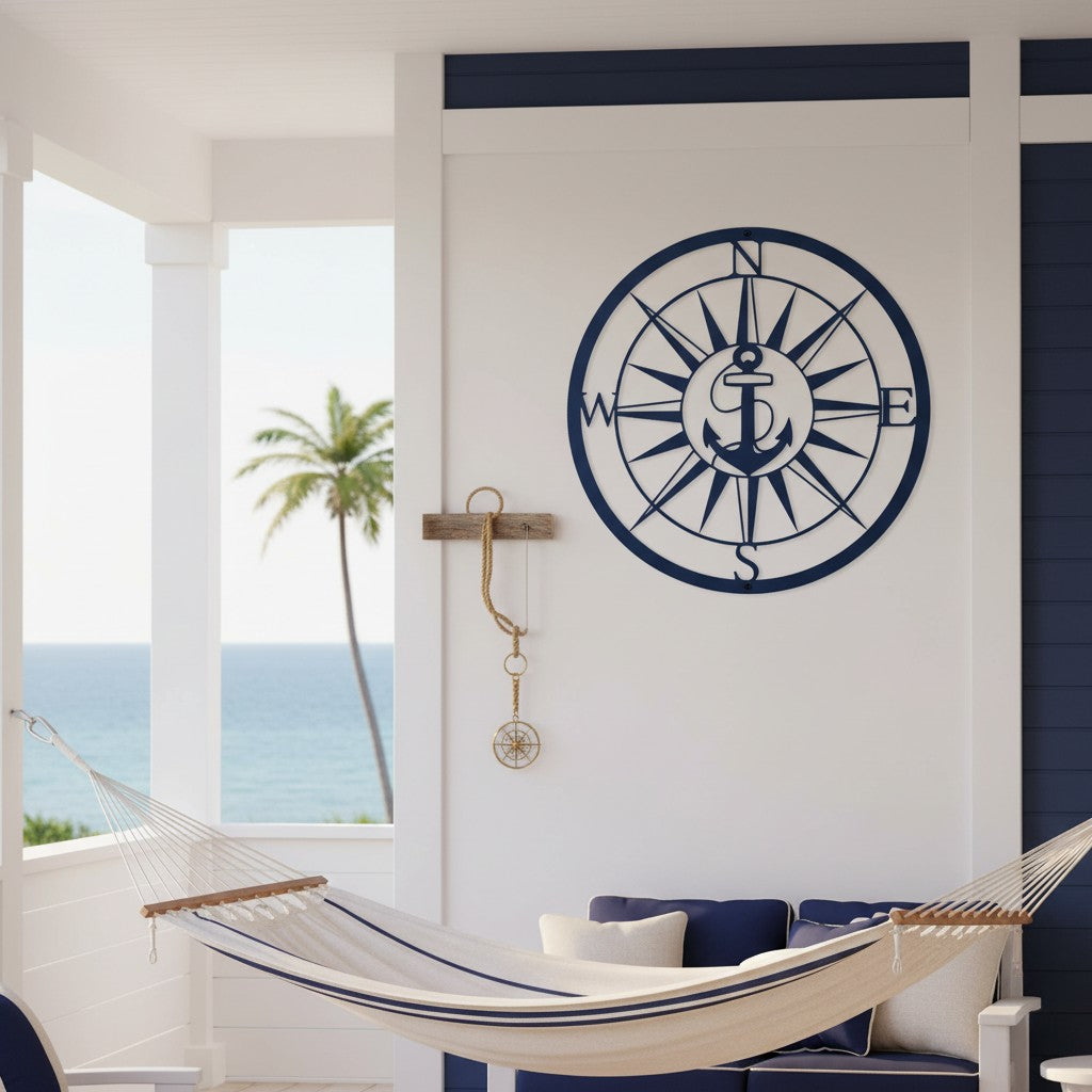 Dark navy blue finish of the custom anchor compass metal plaque mounted on a white structural wall above a striped relaxation hammock on a covered tropical veranda.