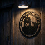 Custom farmhouse metal wall sign with barn and animals illuminated on rustic wood wall outdoor decor at night