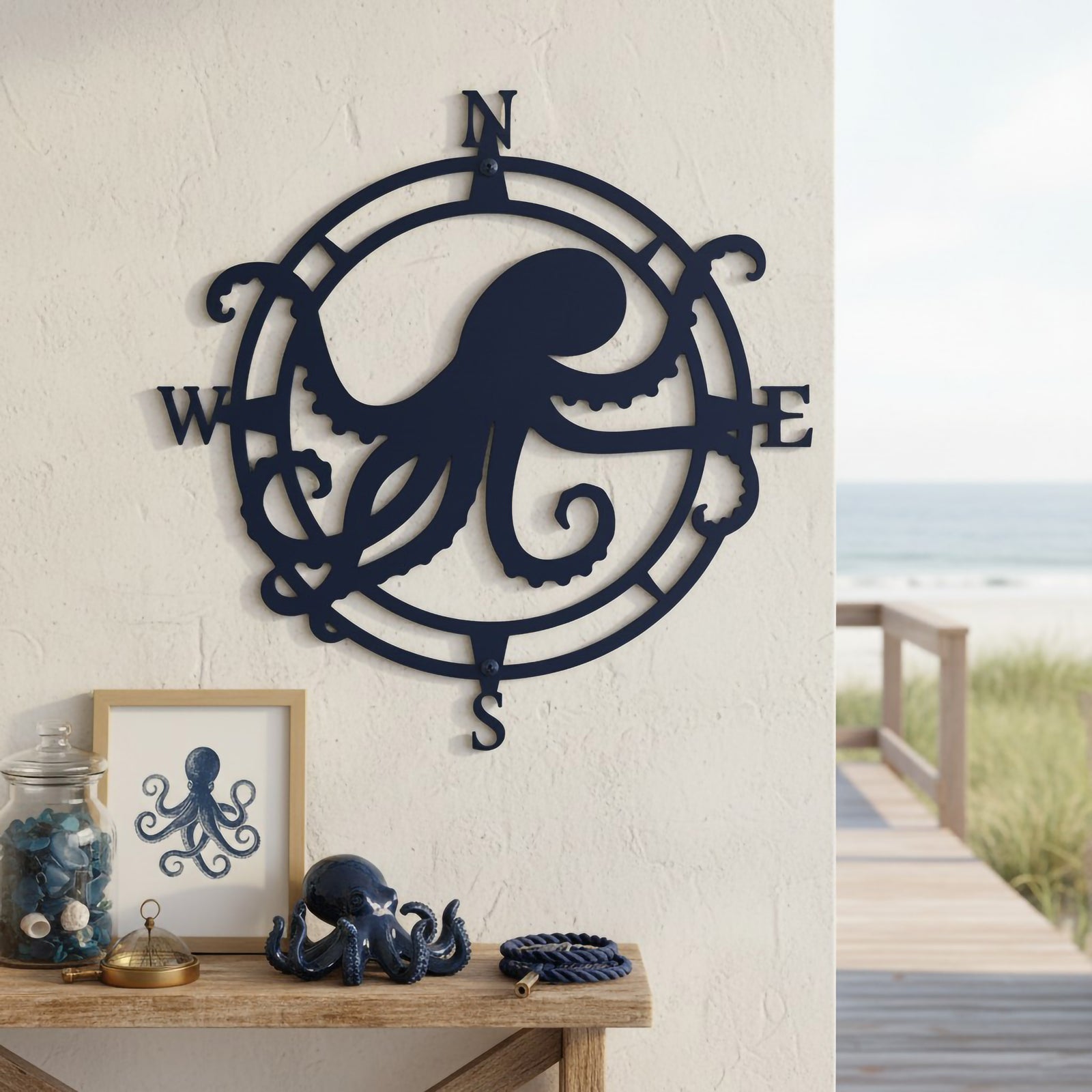 Navy octopus compass metal sign mounted on a coastal wall beside ocean inspired table décor