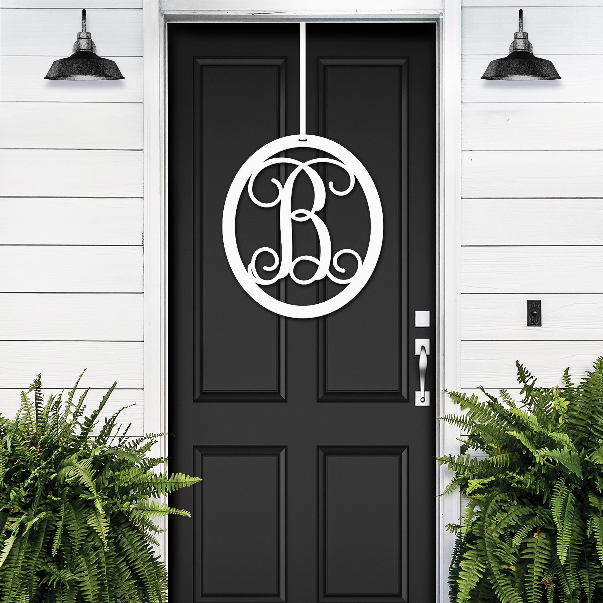 Classy Classic Oval Monogram Door Wreath displayed on a black door, featuring a custom metal monogram. Perfect for personalized home entrances, crafted from durable steel for lasting outdoor use.