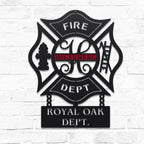 Metal wall art with 'FIRE DEPT' and 'ROYAL OAK DEPT.' text on a white brick background