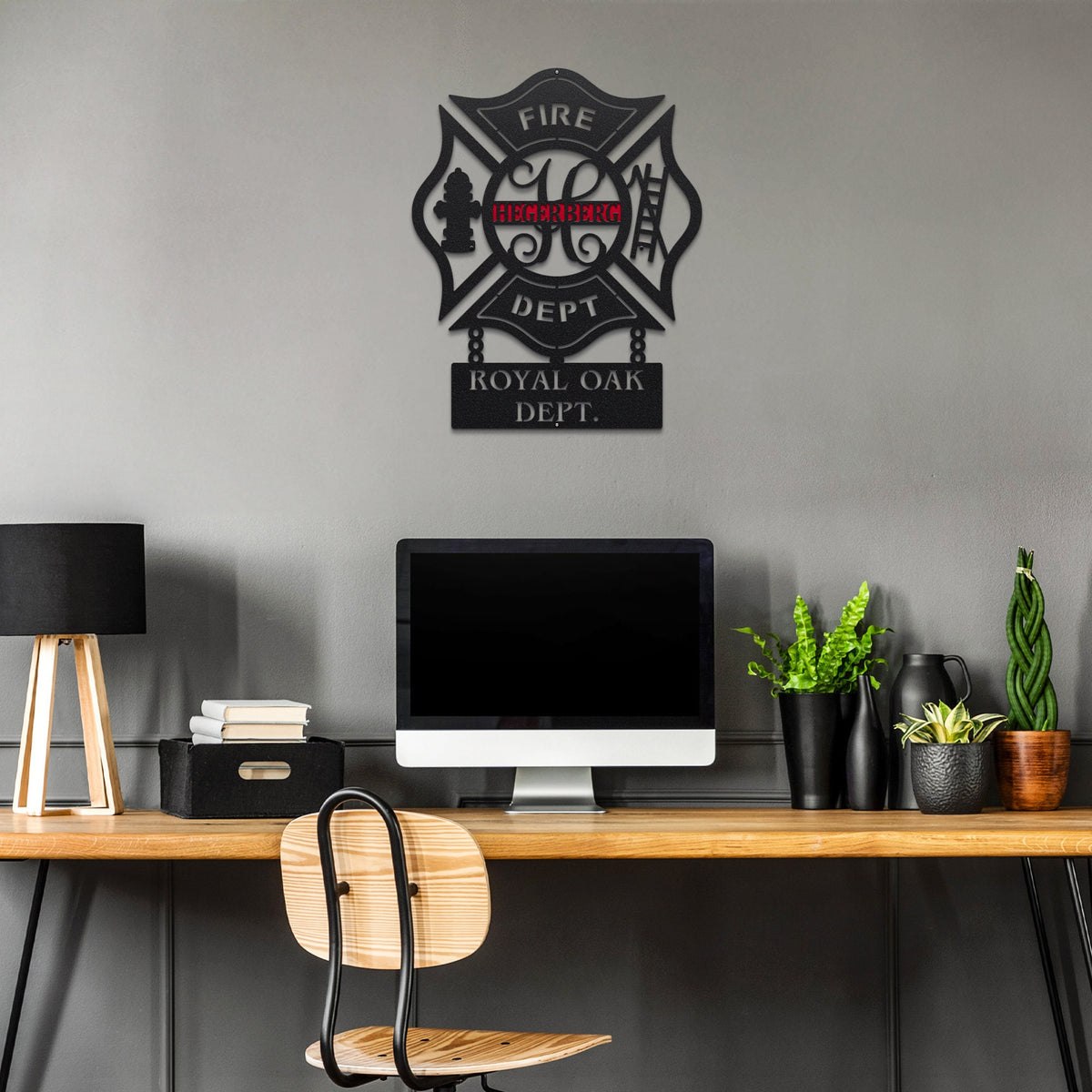 Personalized metal wall art of fire department emblem for 'ROYAL OAK DEPT.' on a gray wall above a desk with office items.