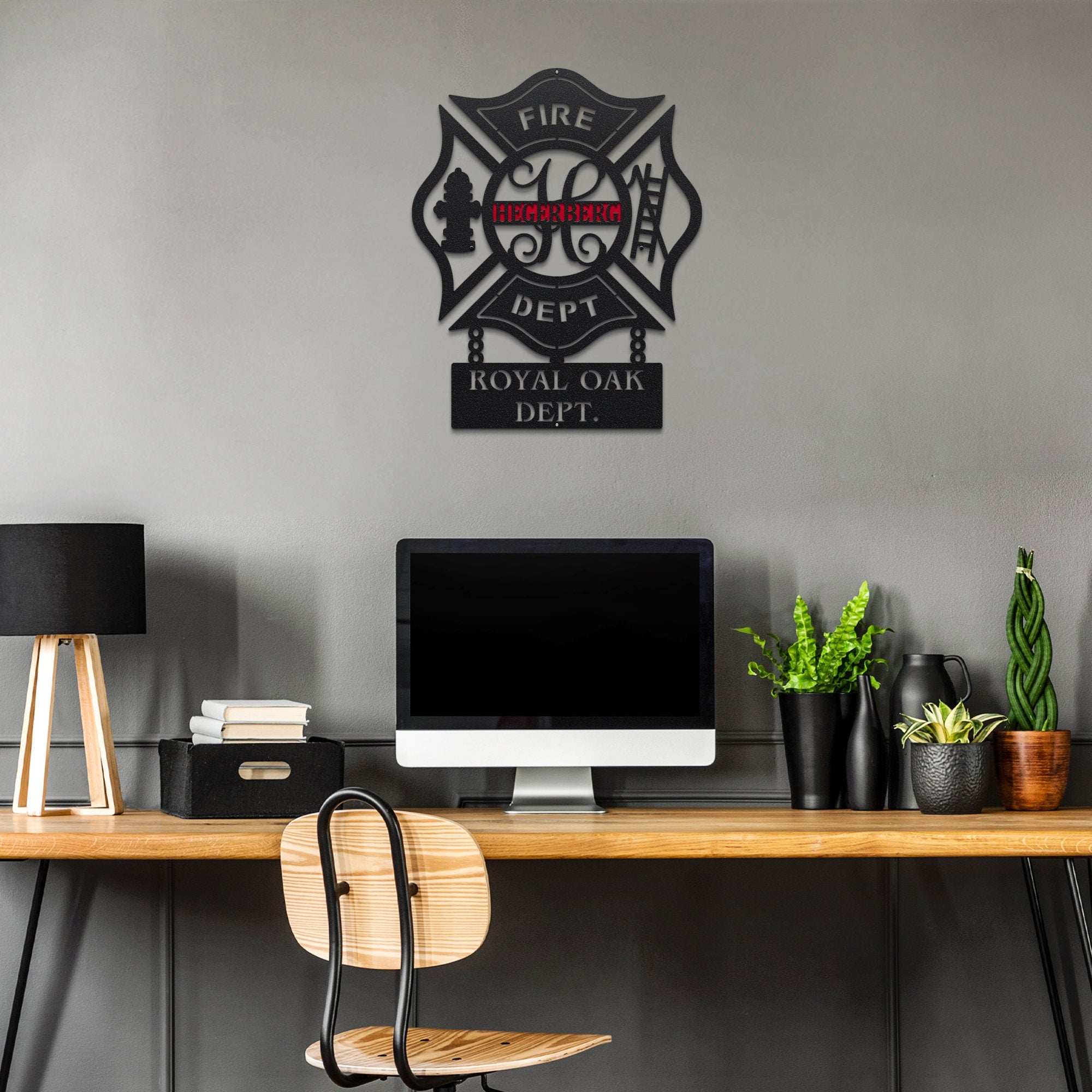 Personalized metal wall art of fire department emblem for 'ROYAL OAK DEPT.' on a gray wall above a desk with office items.