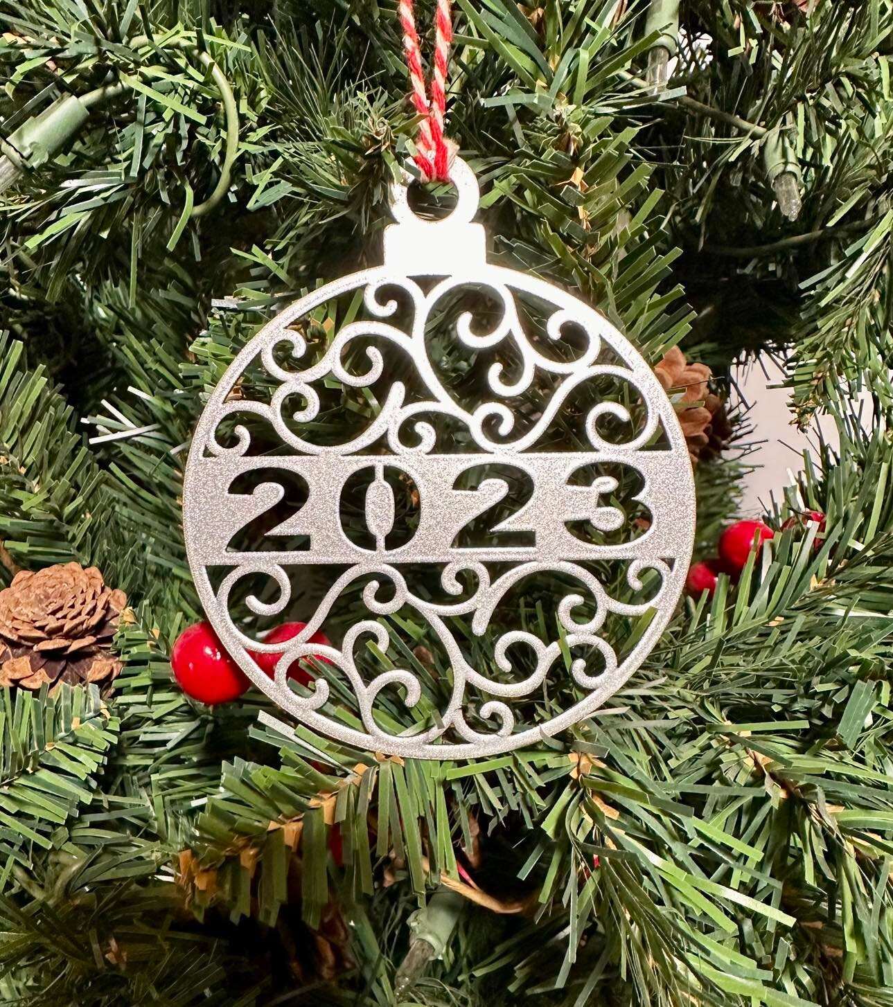 Decorative Christmas ornament with 2023 hanging on tree, festive holiday décor for seasonal display and commemorative ornament collection