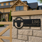 Black custom cattle ranch address sign with house number and street name mounted on stone fence post