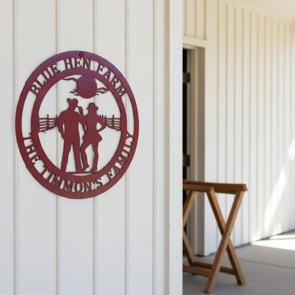 Red custom metal farm sign featuring "Blue Hen Farm" and a cowboy couple silhouette, hung on a wall with white vertical siding near an open doorway.