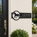 Black custom horse ranch metal address sign displayed beside front entry door