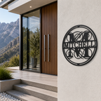 Black circular metal monogram wall sign featuring the Mitchell family name displayed outside a modern luxury home entrance