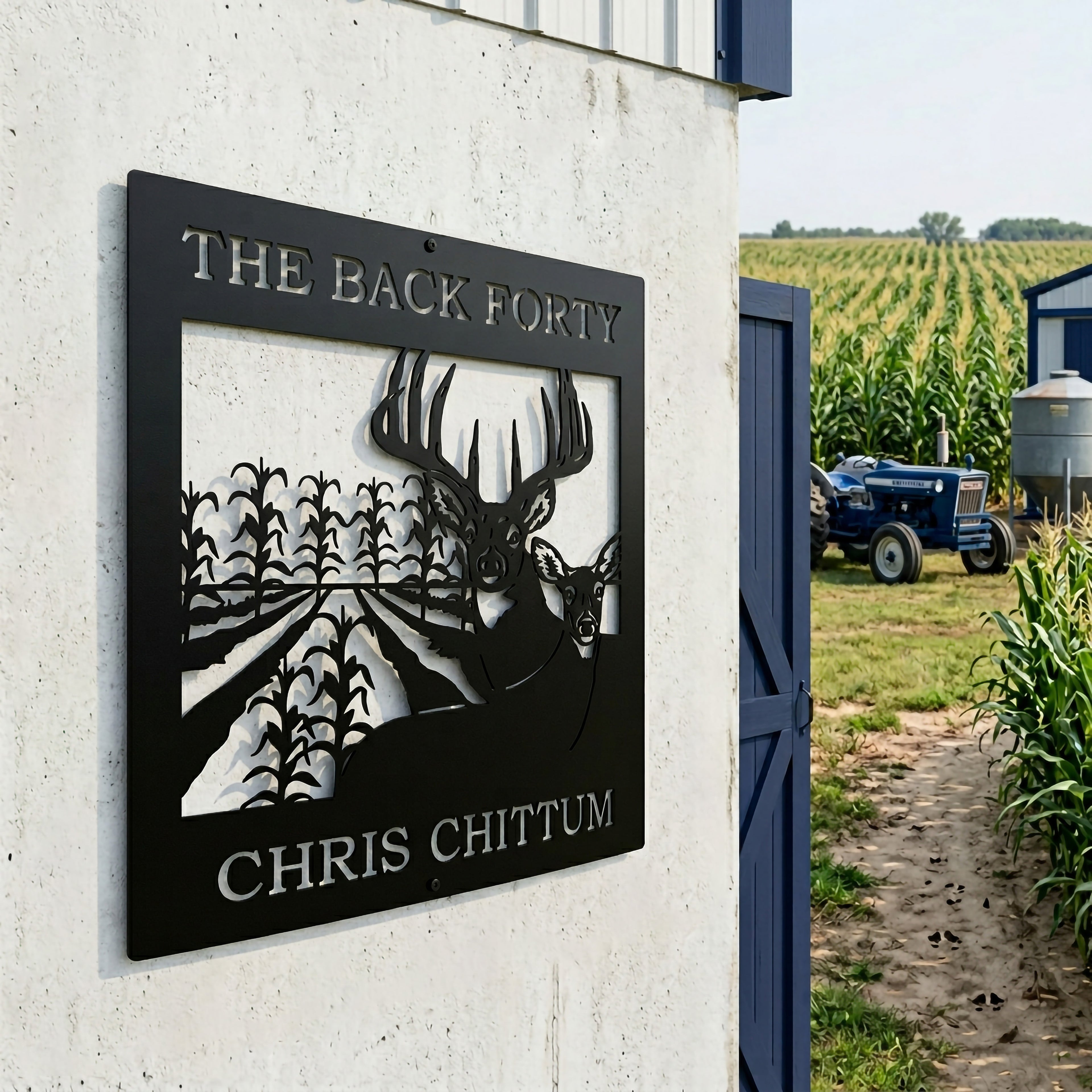 Satin black personalized hunting farm metal sign with deer and cornfield scene displayed near tractor and crop field