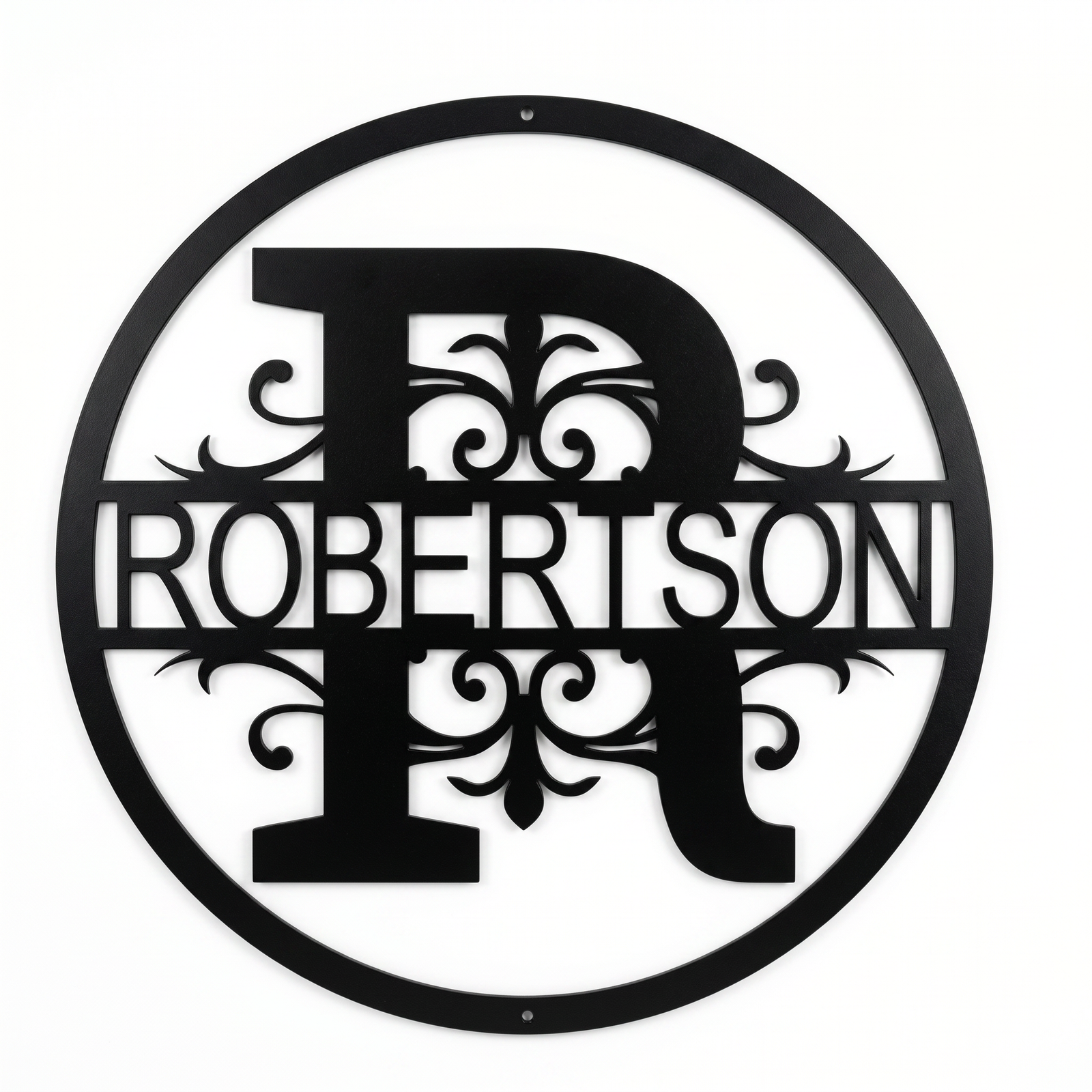 Flat view of a black circular personalized metal sign with a large letter R monogram and decorative scrollwork cut out with the family name Robertson over a pure white background.