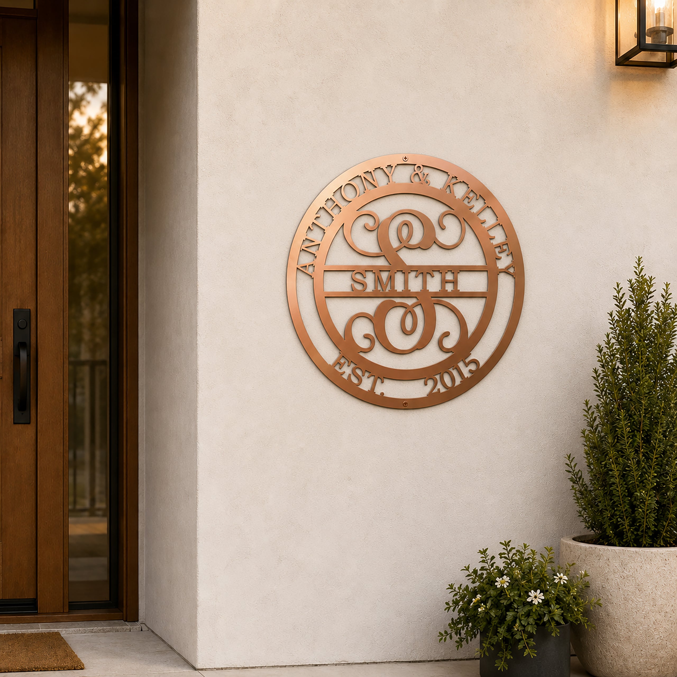 Custom Rose Gold metal monogram sign featuring Anthony and Kelley, family name Smith, decorative letter S, and established date 2015 displayed on an exterior stucco wall near a front entry.