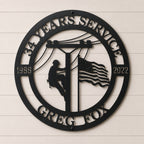 Personalized lineman metal wall sign featuring utility worker climbing power pole with American flag custom years and service company name in black steel décor