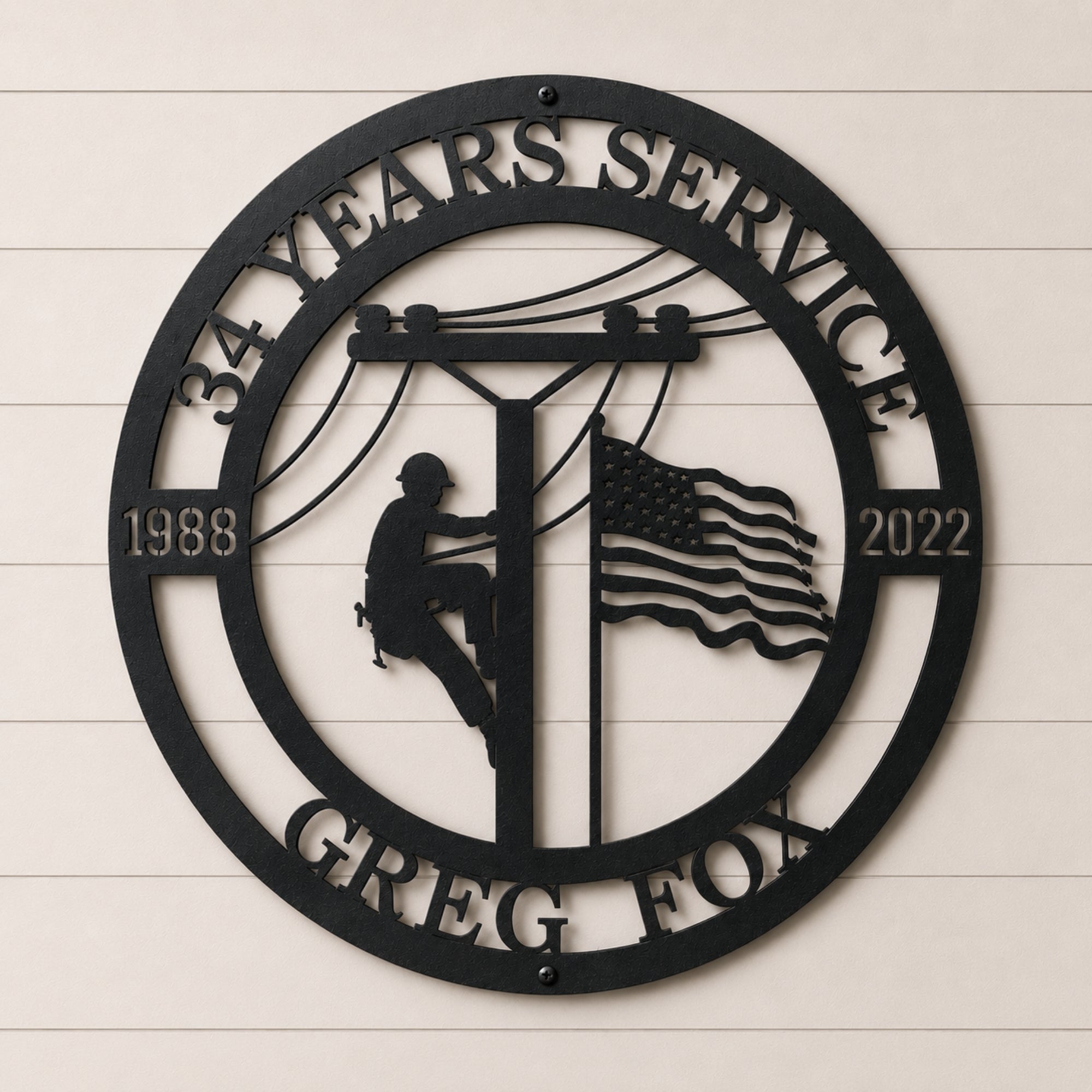 Personalized lineman metal wall sign featuring utility worker climbing power pole with American flag custom years and service company name in black steel décor