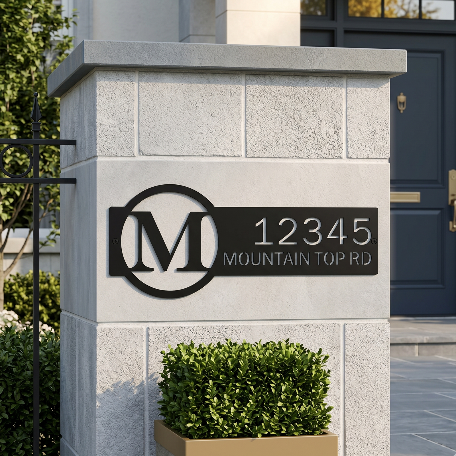 Black personalized metal address plaque mounted on modern outdoor entry pillar
