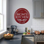 Red moms kitchen metal wall sign featured in bright modern kitchen with mixer stove cookware and fresh ingredients