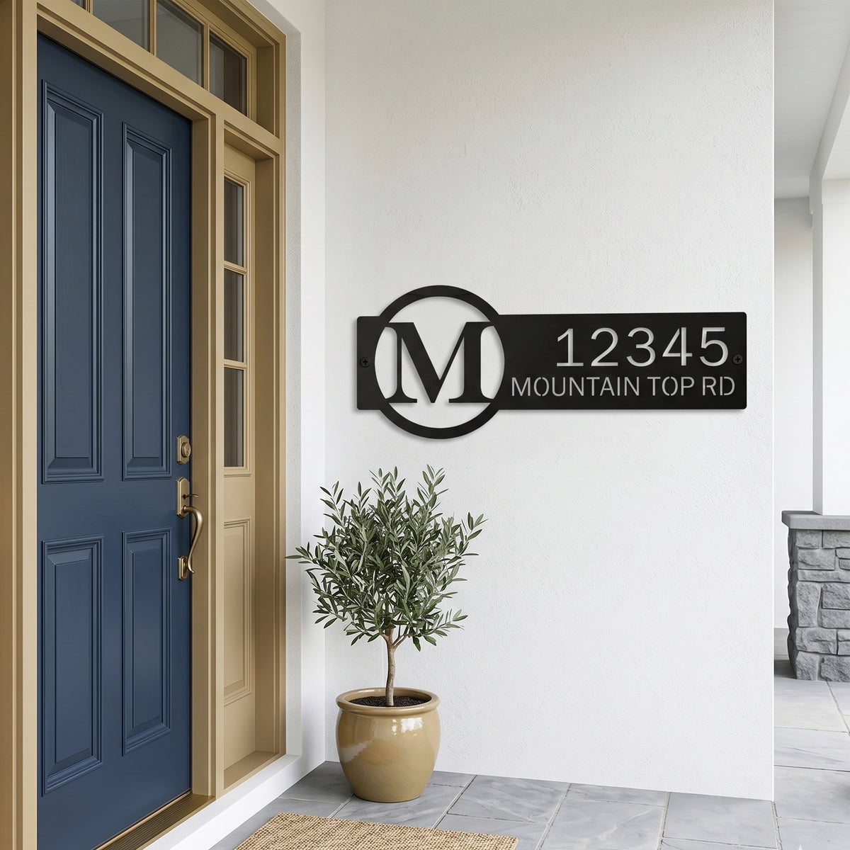 Black personalized monogram metal address sign displayed beside blue front door