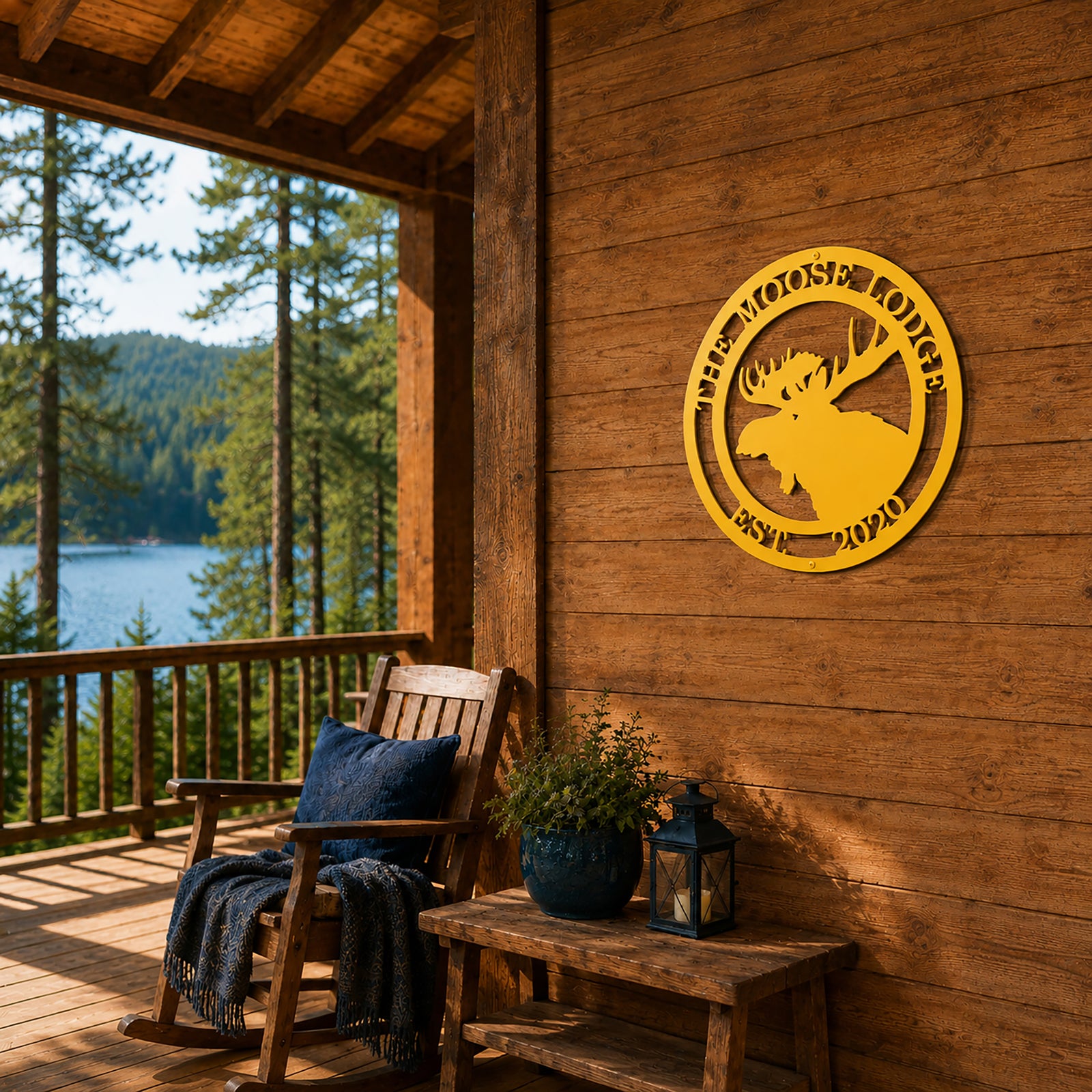 Yellow personalized moose lodge metal wall sign displayed on rustic cabin porch overlooking forest and lake scenery