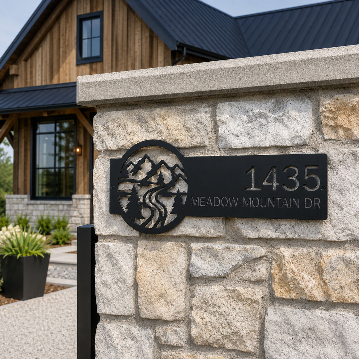 Rustic black mountain address plaque with custom house number and meadow mountain drive text mounted on stone wall outdoor home entrance decor
