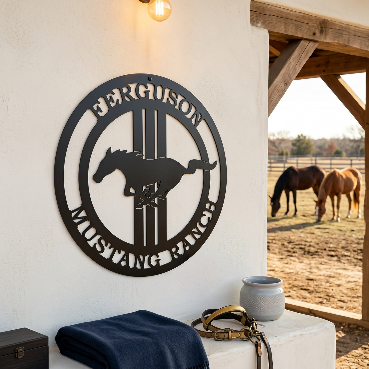 Black personalized Mustang Ranch metal sign with horse silhouette displayed on white stucco wall near horses