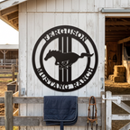 Black Mustang Ranch metal wall sign with running horse design displayed on rustic barn exterior
