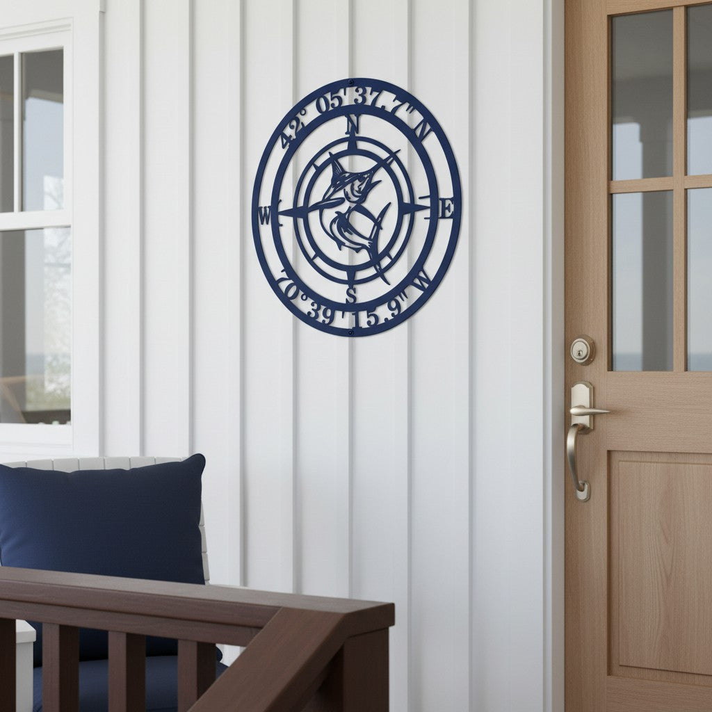 Personalized Nautical Fish Compass Metal Sign in dark navy blue hanging near a wooden front door on a white vertical siding porch wall