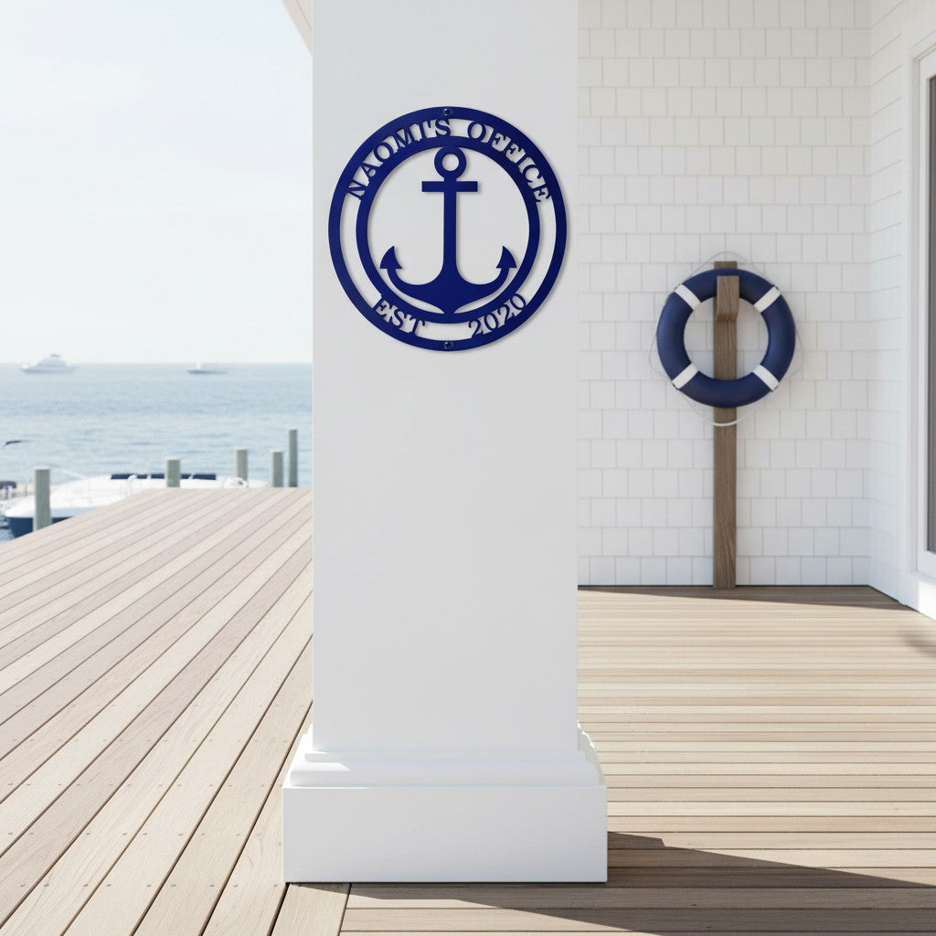 Navy blue finish of the personalized anchor office metal plaque mounted on a white square pillar on an outdoor oceanfront deck next to a life ring decoration.
