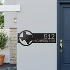 Custom Texas metal address sign with house numbers displayed on modern exterior wall near front entrance