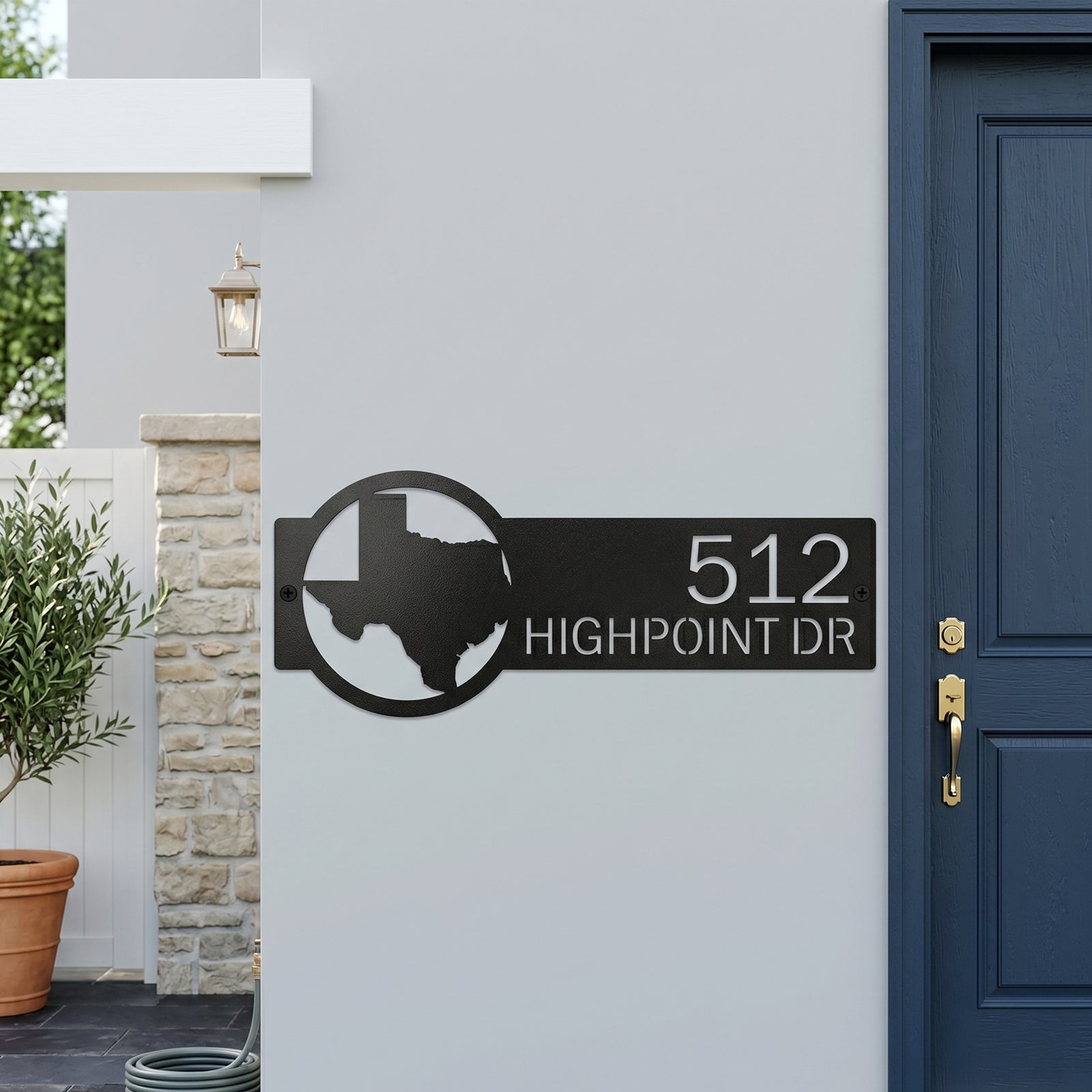 Custom Texas metal address sign with house numbers displayed on modern exterior wall near front entrance