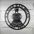 Black metal steam engine train sign with custom name and date on a white rustic wooden shiplap wall background.