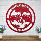 Red chipmunk hollow metal wall art with woodland animal design and tree silhouette mounted on white brick wall decor