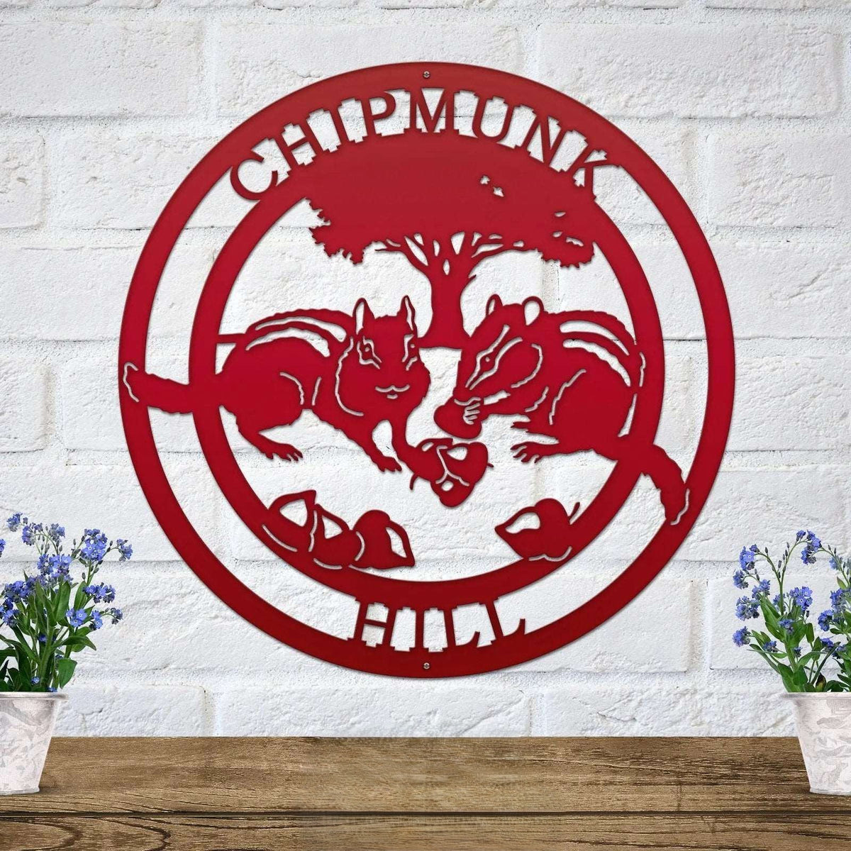 Red chipmunk hollow metal wall art with woodland animal design and tree silhouette mounted on white brick wall decor