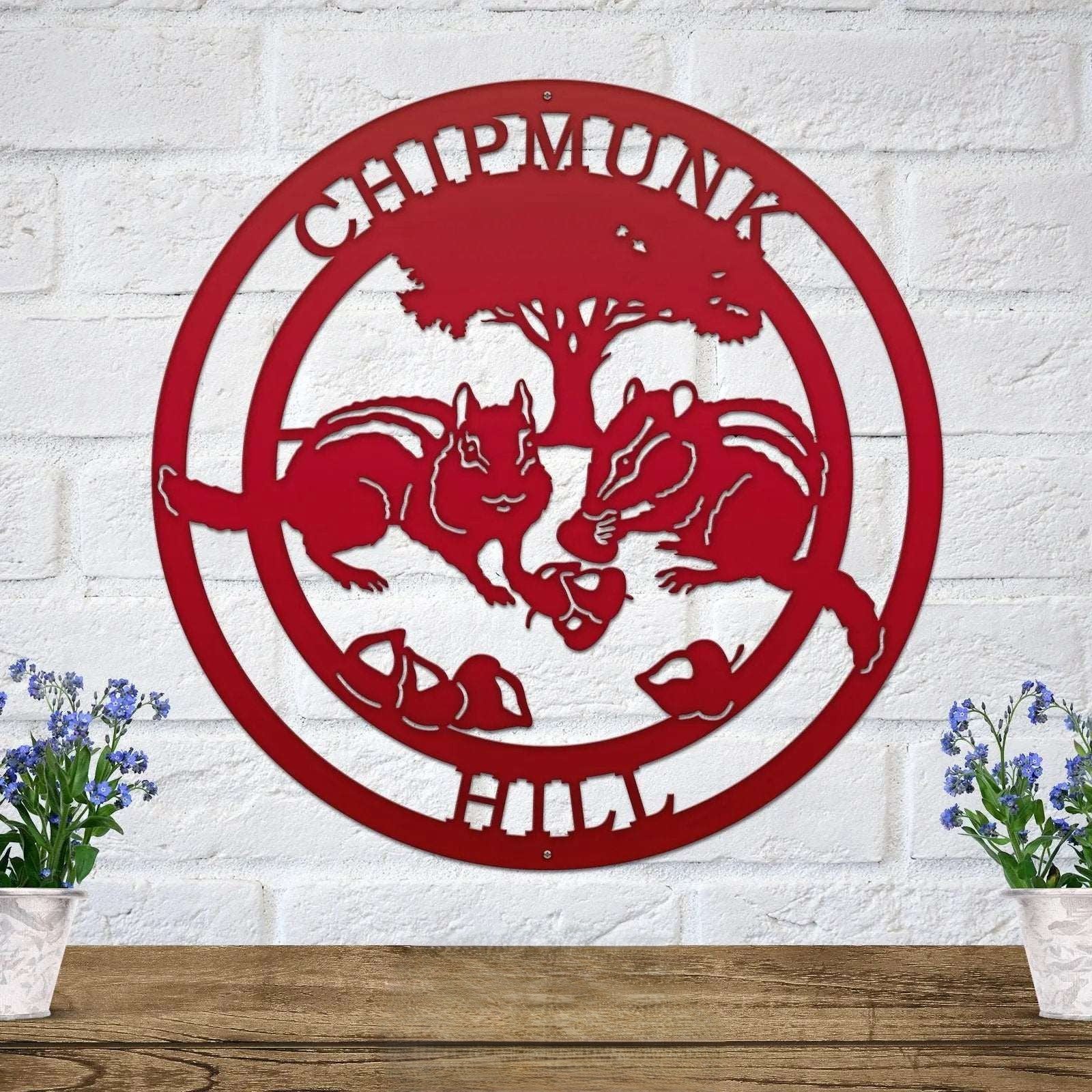Red chipmunk hollow metal wall art with woodland animal design and tree silhouette mounted on white brick wall decor