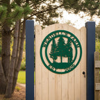A green round metal farm sign reading "Wendell's Farm Est. 2006" fixed to a light wood arched gate supported by dark blue posts at a property entrance.