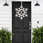 Personalized snowflake monogram door hanger in white displayed on black front door for winter porch decor and holiday entryway style