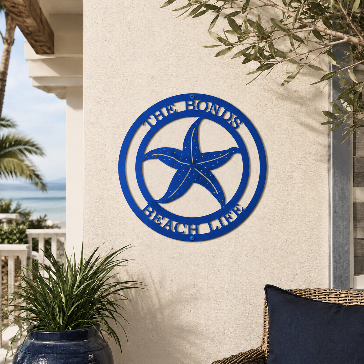 Vibrant blue custom metal starfish family sign mounted on an outdoor stucco wall above a large glossy blue planter on a sunny patio.