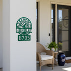 Custom Bionic Green metal address sign featuring a tree design, family name Hundley, and house number 8705 displayed on a covered front porch wall.