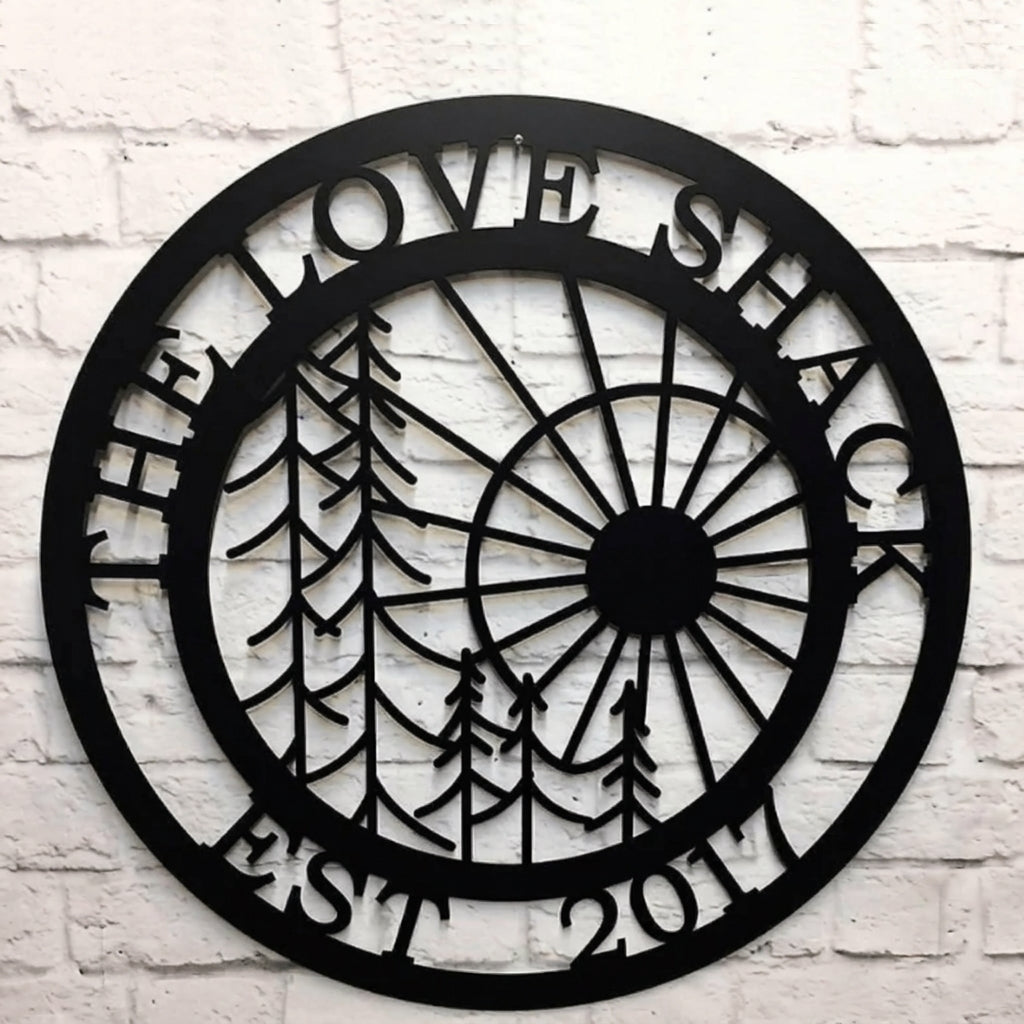 Close up of personalized tree and sun metal wall sign with custom family name and established year in black steel finish