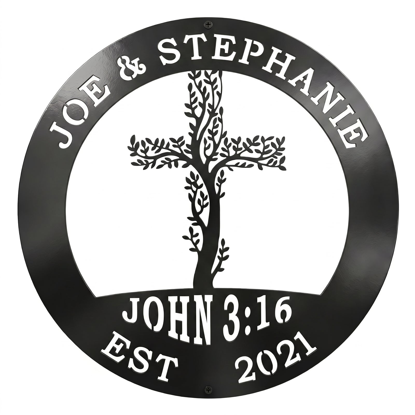 A circular metal sign finished in a glossy black color is displayed over a solid white background. The top rim is cut out with the names "JOE & STEPHANIE," the bottom features "JOHN 3:16 EST 2021," and the center showcases an intricate cross woven with climbing tree branches and leaves.