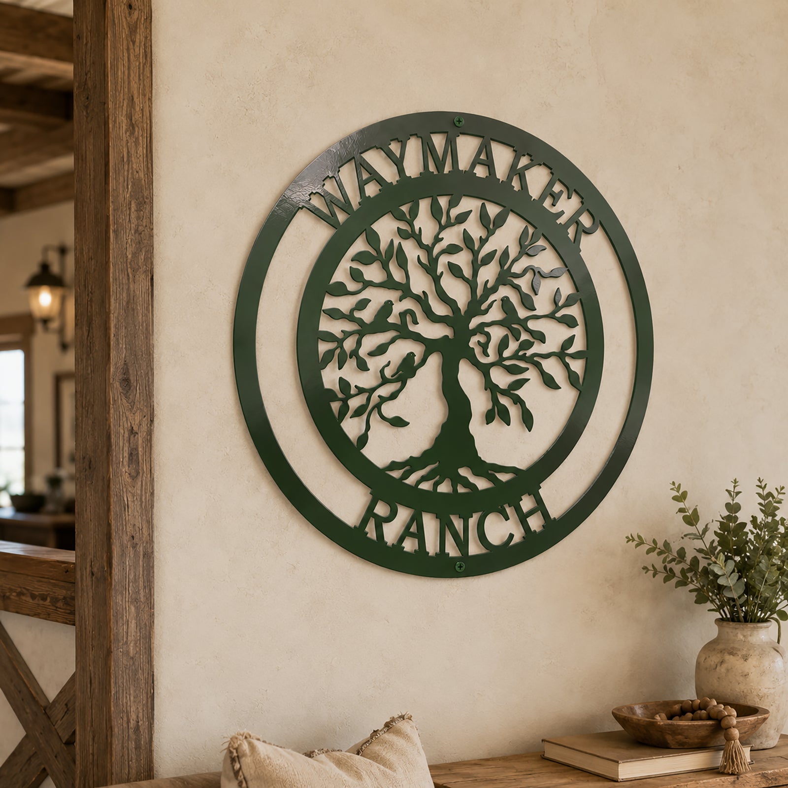 Bionic green custom metal tree of life sign reading "Waymaker Ranch", mounted on a textured beige indoor entryway wall next to a wooden doorframe.