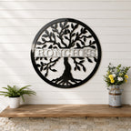Large black tree of life metal wall sign with personalized family name displayed on white shiplap wall with rustic decor