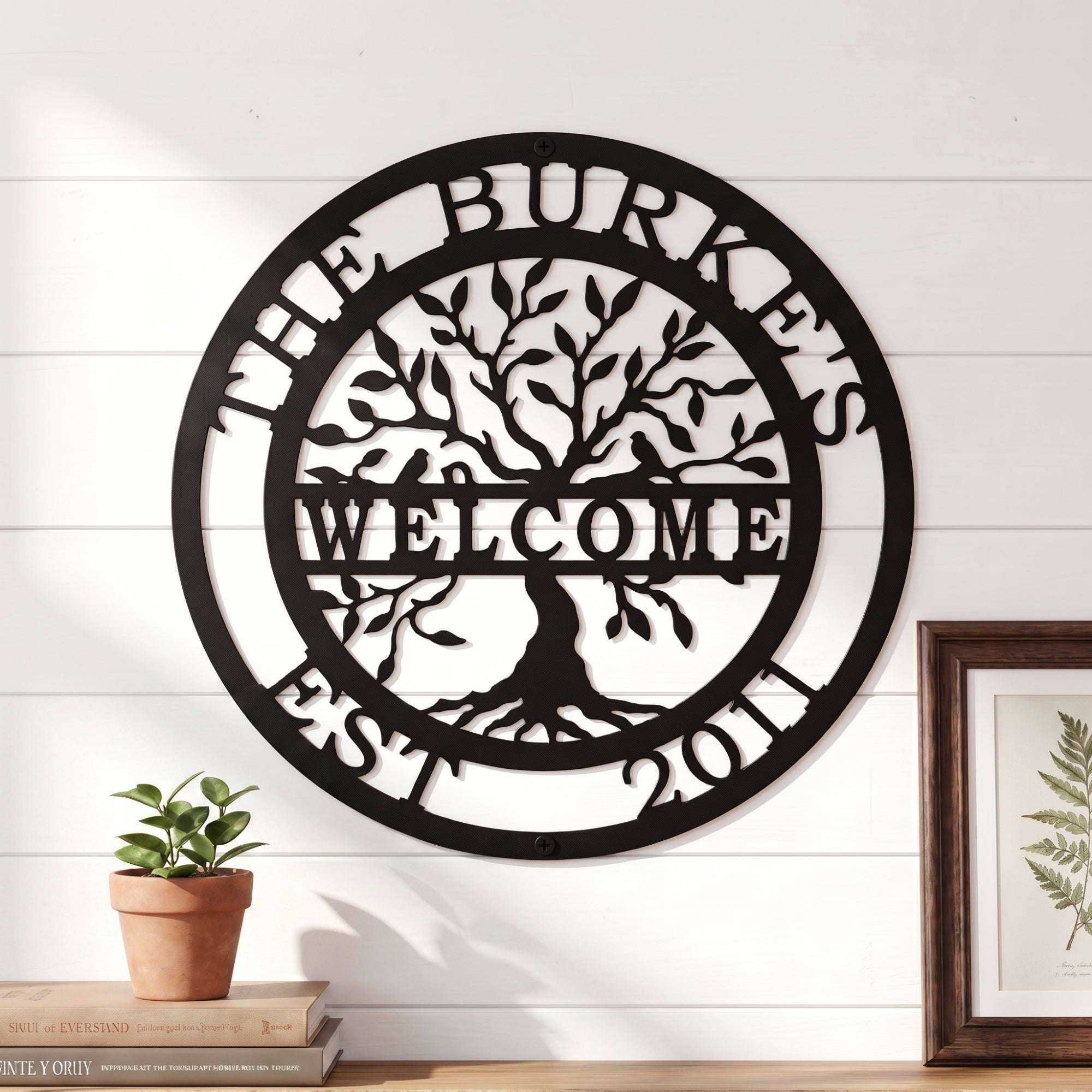 Close up of personalized tree of life metal welcome sign with custom family name and established date on white shiplap wall