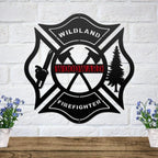 Black metal Maltese cross sign with axes, chainsaw, and tree, featuring a personalized red Woodward nameplate.