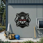 Wildland firefighter custom metal sign mounted on exterior wall beside chainsaw safety helmet and firefighting equipment