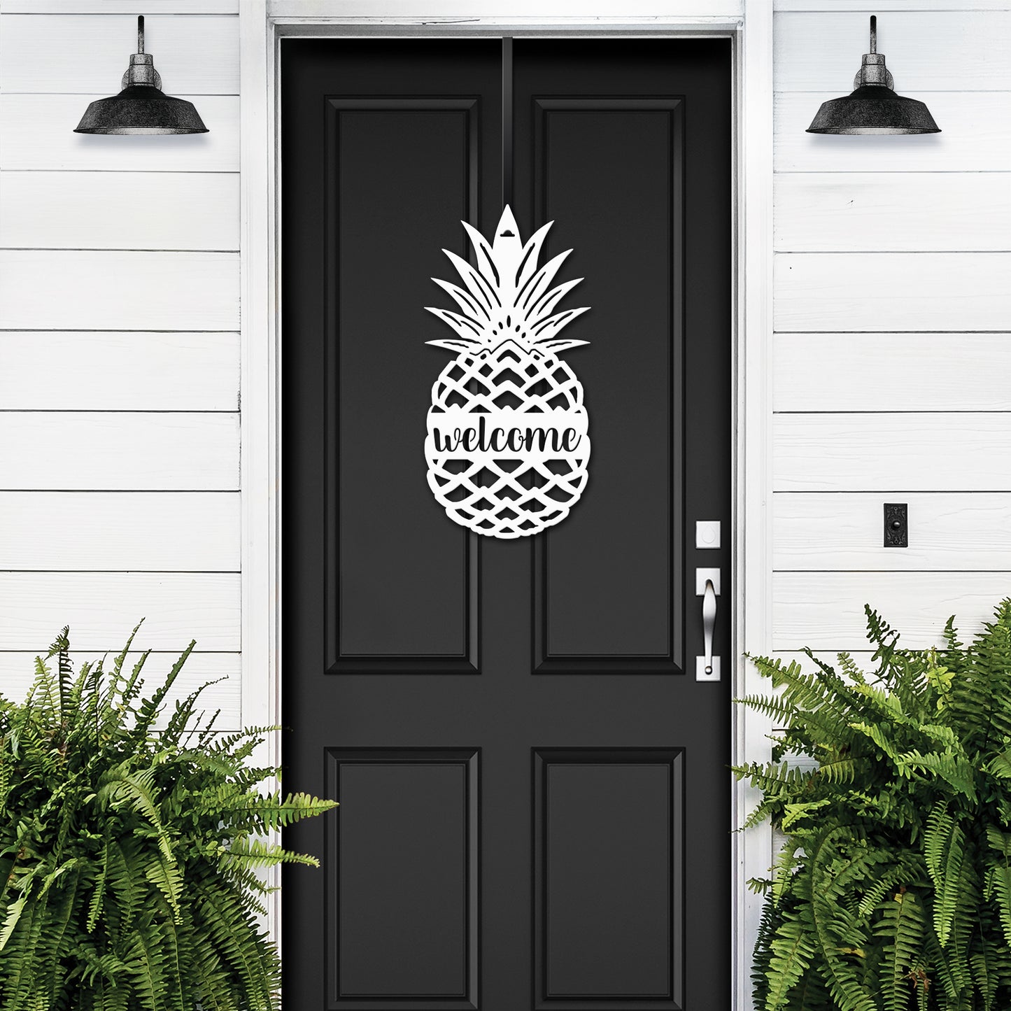 Welcome Pineapple Front Door Sign featuring a pineapple motif, mounted on a black door, symbolizing hospitality. Ideal for home décor and housewarming, crafted from durable, weather-resistant metal.