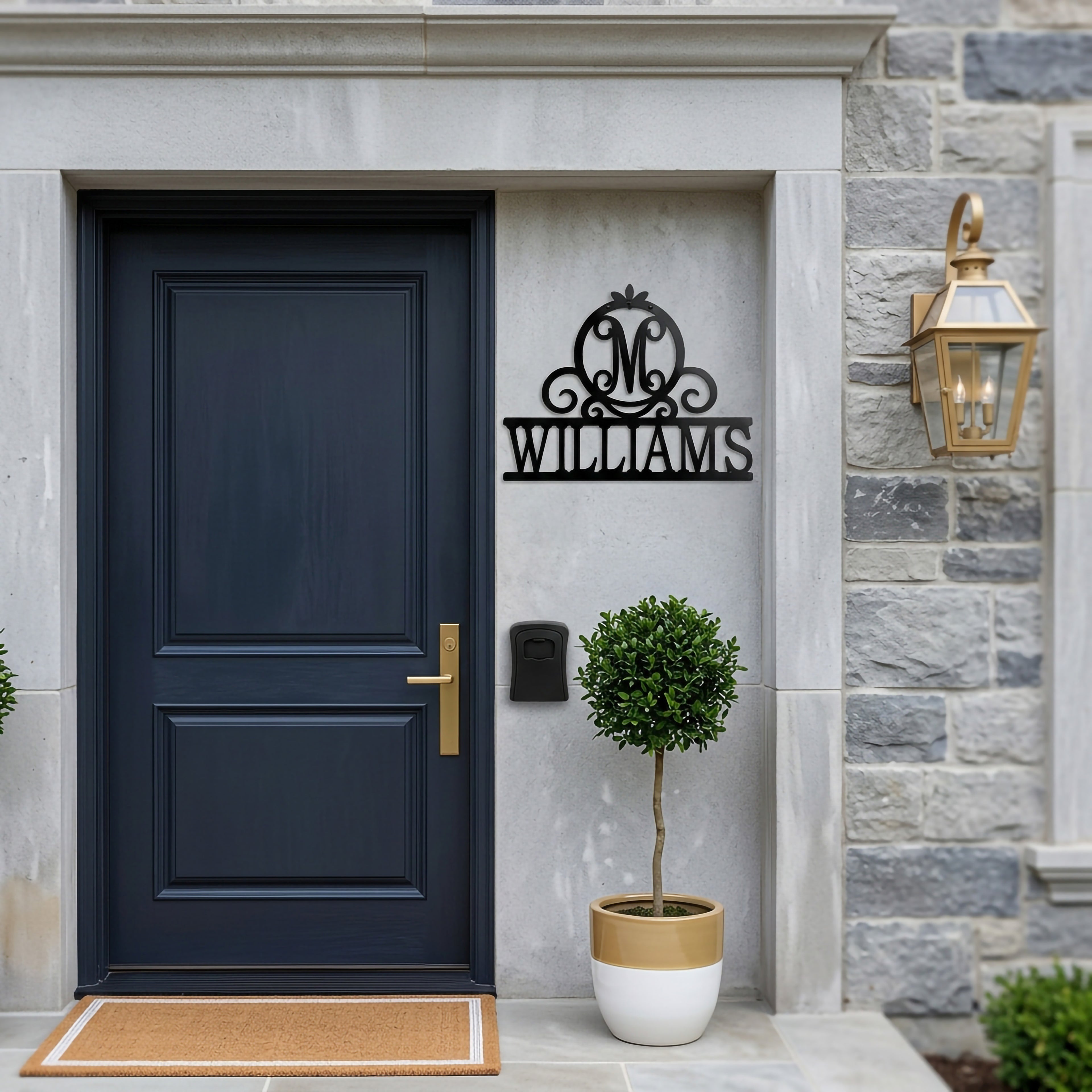 Personalized Williams metal name sign mounted beside a modern navy blue front door with stone exterior and decorative lantern