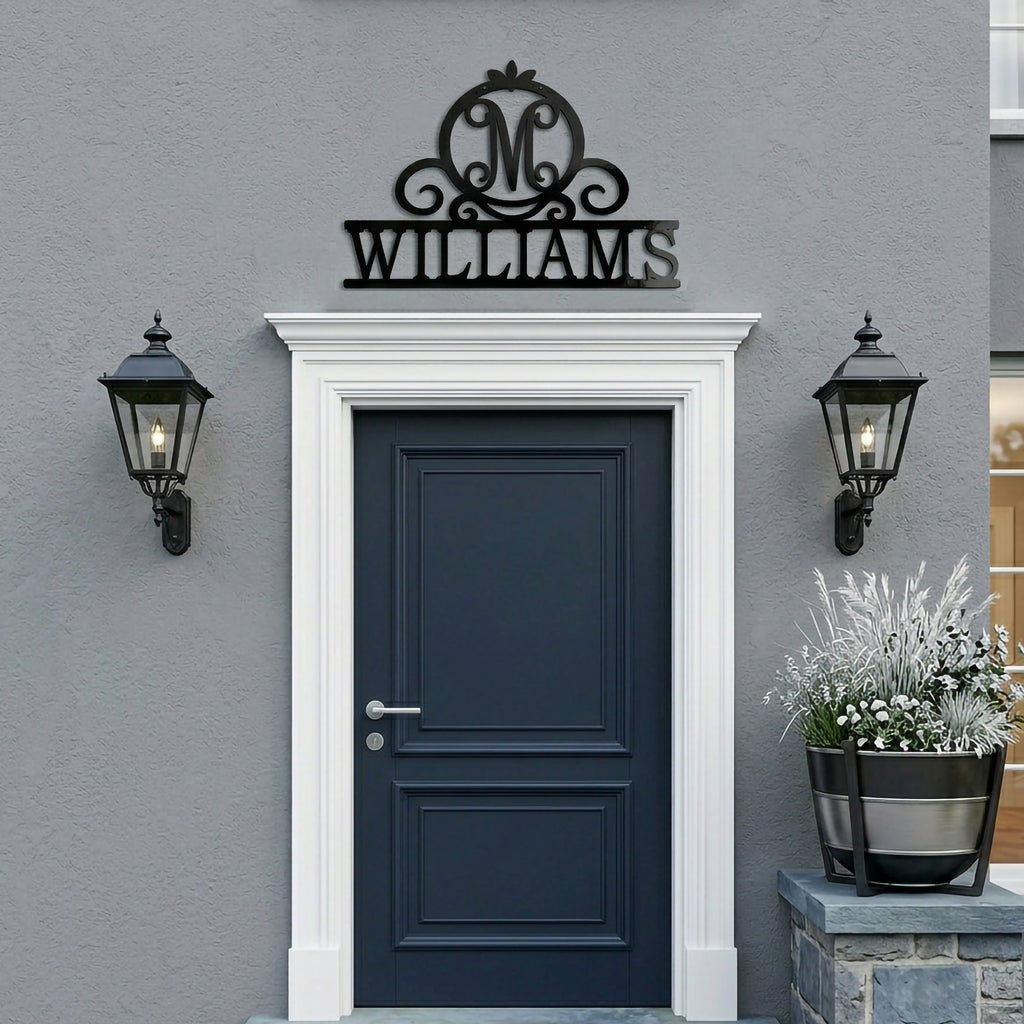 Black Williams monogram metal family sign displayed above a modern exterior front door with black lantern wall lights and gray stucco wall