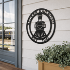 Black Becker Railroad locomotive metal wall decor displayed on exterior siding beside train station platform