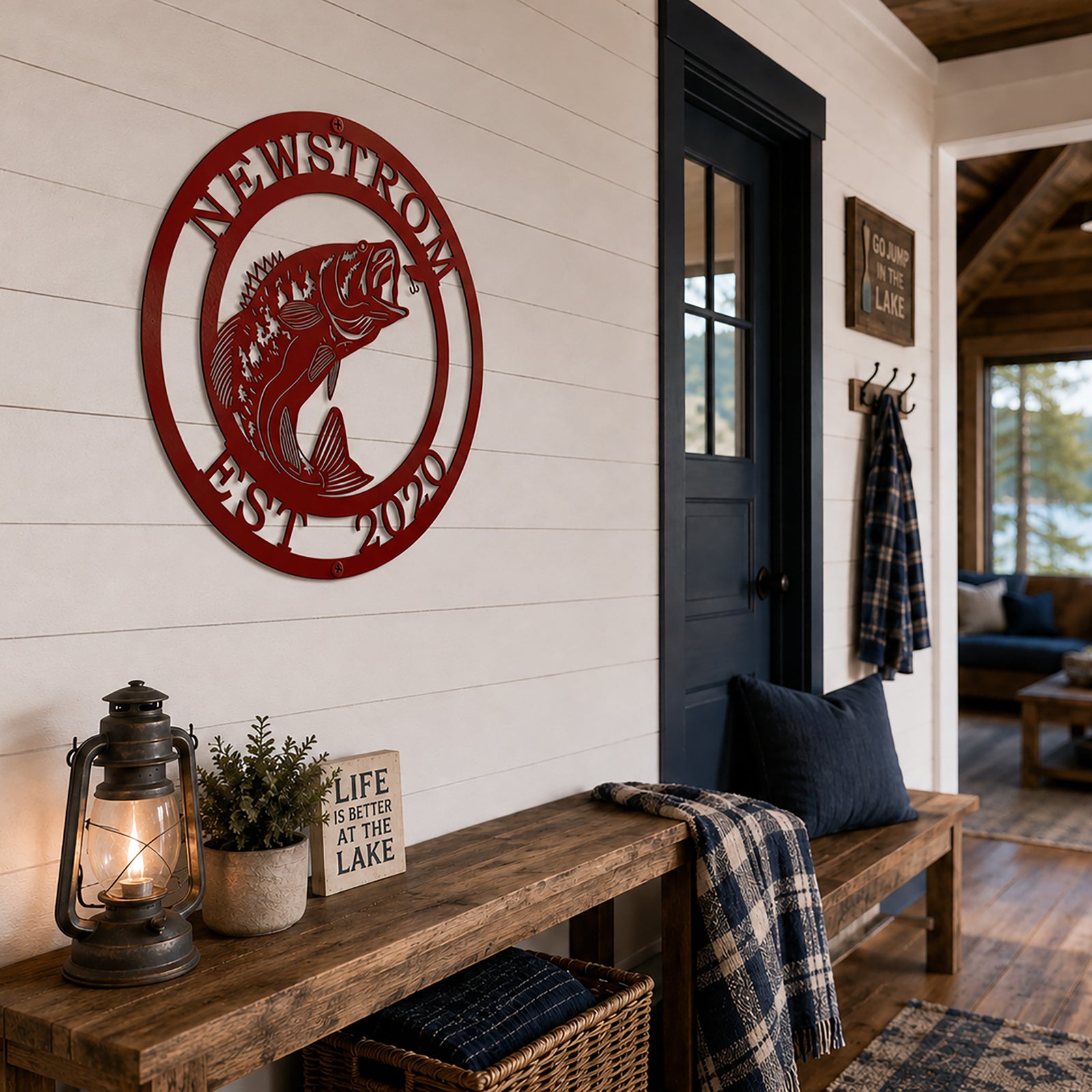 Red bass fish metal sign with Newstrom and Est 2020 displayed on a white shiplap lake cabin entryway wall