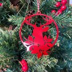 Red deer-shaped Christmas ornament hanging on green tree with red berries, festive holiday decoration for seasonal décor and Christmas tree display